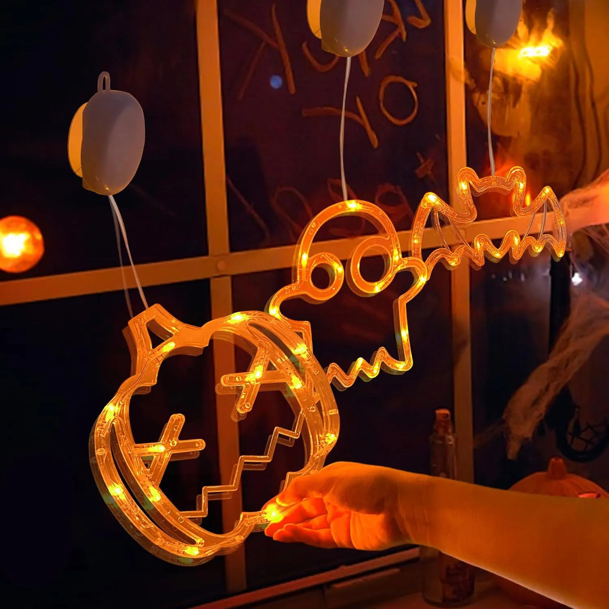 Close view of orange Halloween lights hanging beside a window