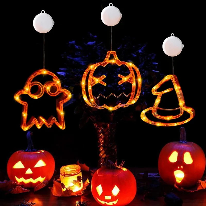 Glowing ghost, pumpkin and witch hat decorations above festive pumpkins