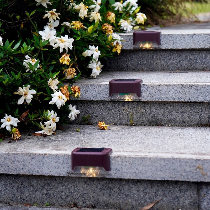 Brown solar deck lights with warm illumination on garden steps